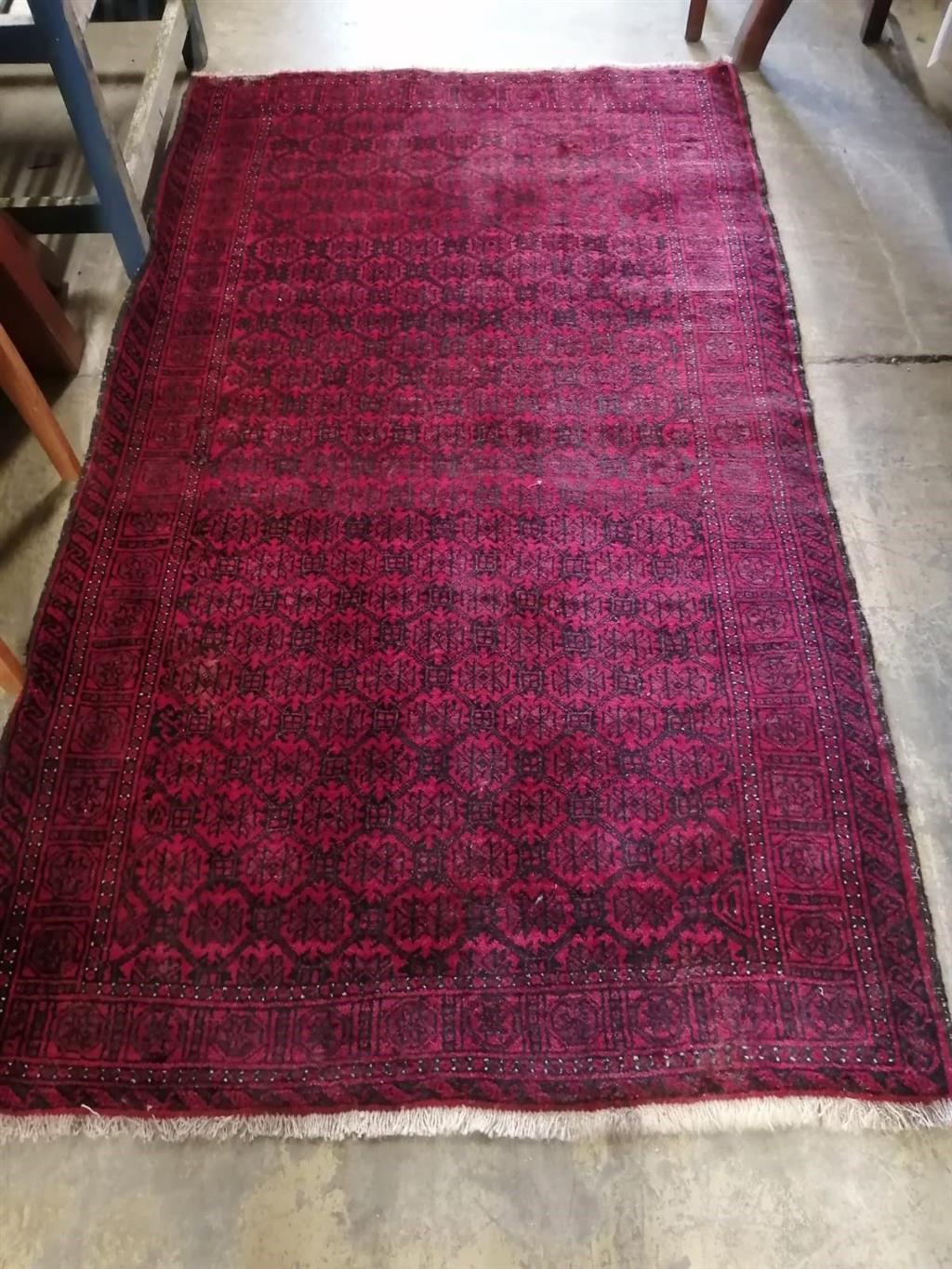 A Caucasian red ground rug, 204 x 115cm